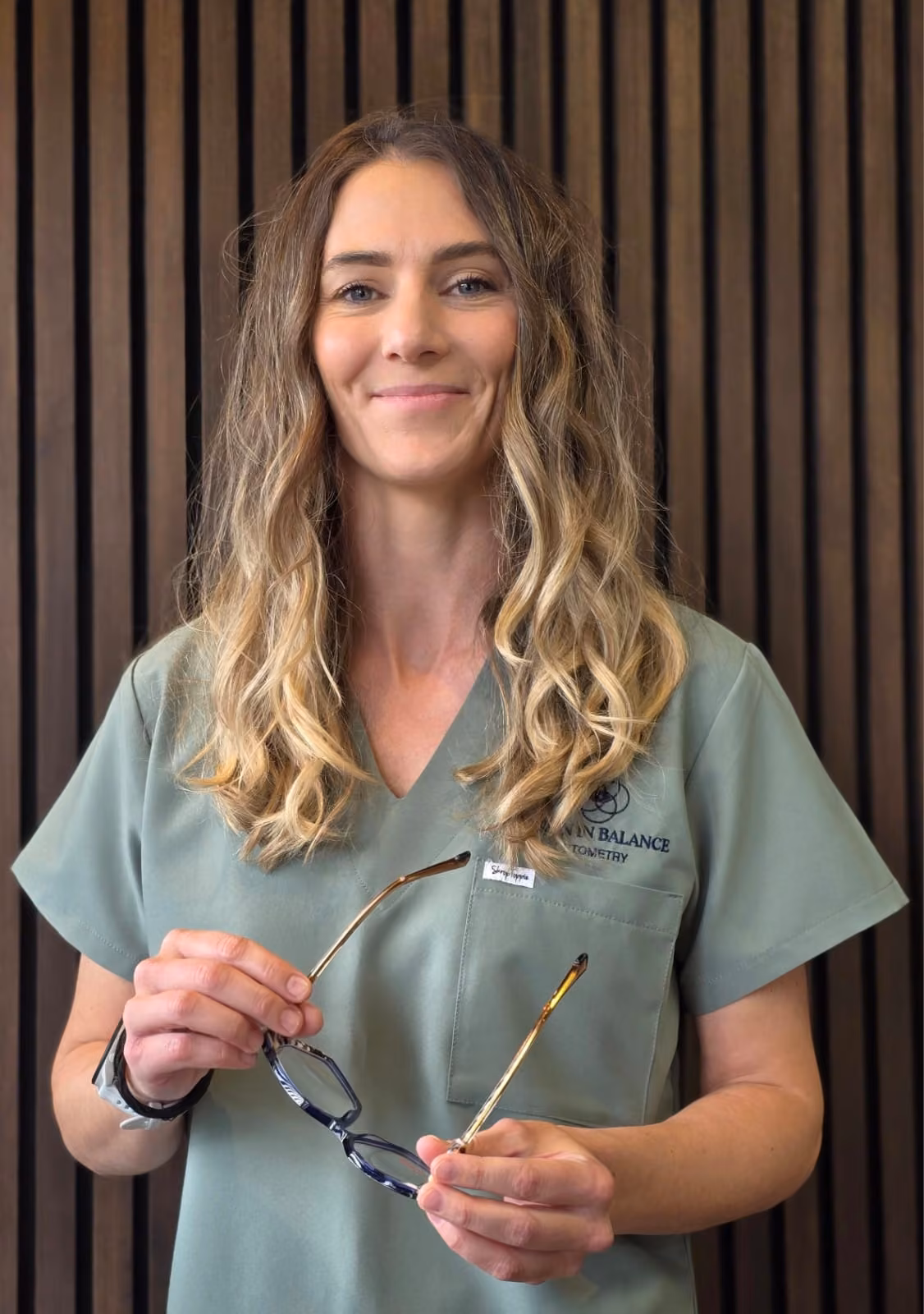 Optometrist Amy Daly holding a pair of glasses at Vision in Balance